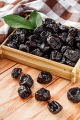 delicious dried prunes on a wooden rustic background