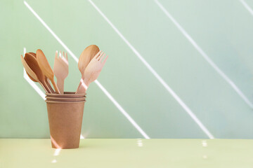 Wooden spoons and forks in paper glass. Copy space, zero waste concept.