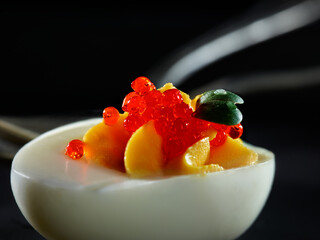 Filled egg with caviar and fresh green