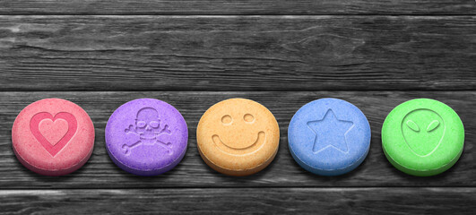 MDMA or Ecstasy pills on dark wooden background - obrazy, fototapety, plakaty