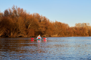 Confident woman kayaking on river alone near trees. Sport, relations concept