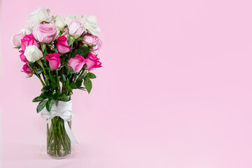 Arreglo de rosas sobre fondo rosa.