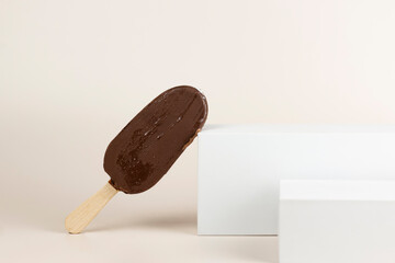 Chocolate ice cream bar with sticks. Popsicle and lolly sweet dessert on white platform with copy...