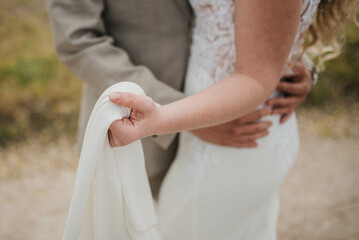 Obraz premium Bride in beautiful white wedding dress with bouquet and elegant groom in suit at happy wedding day. 