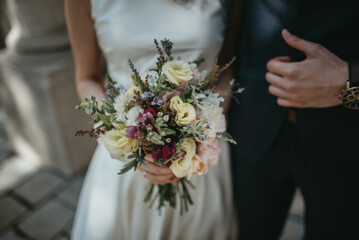 Bride in beautiful white wedding dress with bouquet and elegant groom in suit at happy wedding day. 