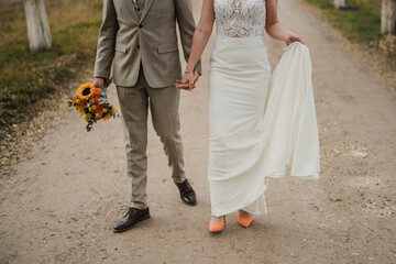 Obraz premium Bride in beautiful white wedding dress with bouquet and elegant groom in suit at happy wedding day. 