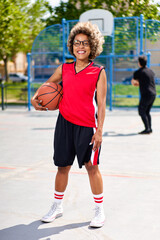 sports girl outdoors preparing for training, holding a basketball