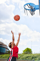 Basketball player performing slam dunk on a street court. Woman in sportswear playing streetball on...