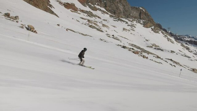 Woman Skiing Down Hill Under Clear Blue Sky