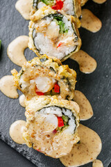 delicious sushi rolls on a black stone background