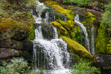 Beautiful mossy summer waterfall in nature