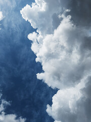 Cumulus clouds diagonally against a dark blue sky