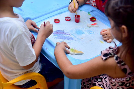 children painting with brush and colored paints, school activity, child education, children in the classroom, elementary School, Children's Day, Teacher's Day, recreational activity, school group