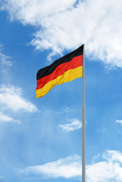 Flag of Germany in front of blue sky and clouds