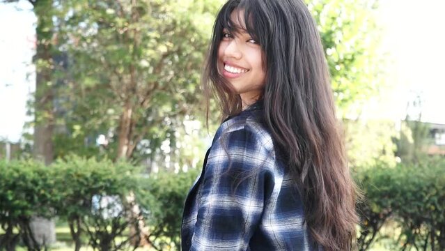 Mujer latina sonriendo en un parque al atardecer. Concepto de personas.