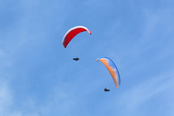 	
Paragliders in a blue sky	