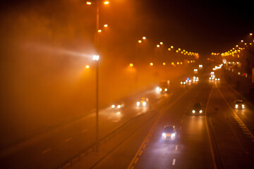 Blurred motion picture in Kyiv at night in the fog. Kind of traffic on a busy street at night - the...