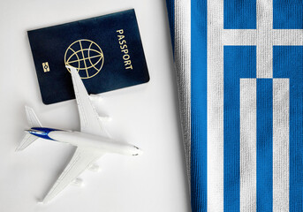 Flag of Greece with passport and toy airplane. Flight travel concept 