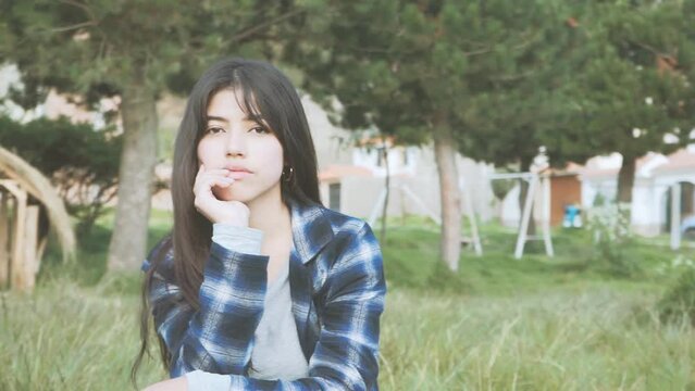 retrato de mujer latina sentada en un parque (C&aacute;mara en movimiento) Concepto de gente.