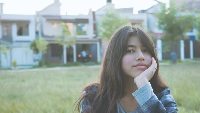retrato de mujer latina sentada en un parque (C&aacute;mara en movimiento) Concepto de gente.