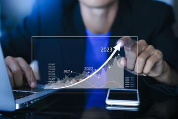 Businessman using a computer show plan business growth and financial, increase of positive indicators to increase business growth and an increase for growing up business from year 2021-2023