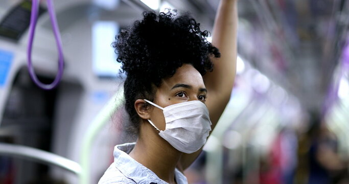 Young Black Woman Commuting In Subway Holding Handrail Wearing Face Mask