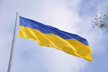 flag of ukraine on a flagpole against a blue sky