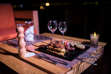 A plate of Chicken and beef BBQ with grilled tomatoes, potatoes and onions 