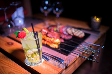 A plate of Chicken and beef BBQ with grilled tomatoes, potatoes and onions 