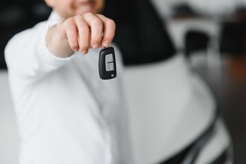 Happy man showing the key of his new car.