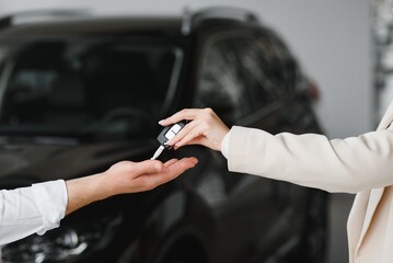 businessman exchange handing over the car keys for to a young women.