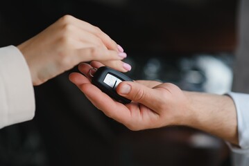 Fototapeta premium businessman exchange handing over the car keys for to a young women.