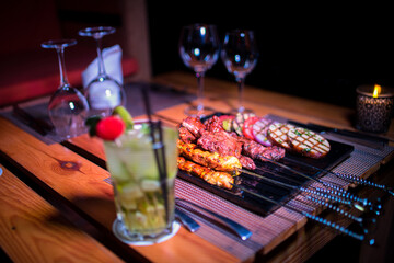 A plate of Chicken and beef BBQ with grilled tomatoes, potatoes and onions 