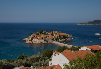 Fototapeta na wymiar Sveti Stefan Island on a summer sunny day. Hot summer morning. Rest by the sea. The best holiday. Budva, Montenegro.