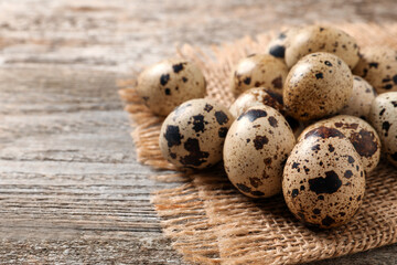 Obraz premium Fresh quail eggs on wooden table. Space for text