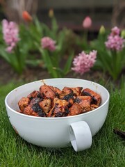 bbq cubes of pork in the white bowl on the grass