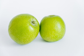green and ripe apples on white.