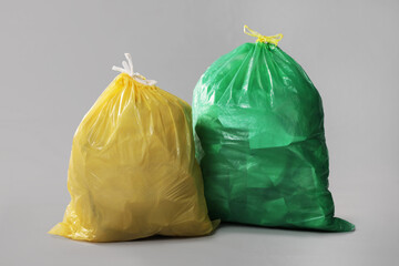 Trash bags full of garbage on grey background