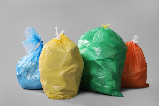 Trash bags full of garbage on grey background