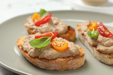 Fototapeta na wymiar Slices of bread with delicious pate, tomatoes and basil on plate, closeup