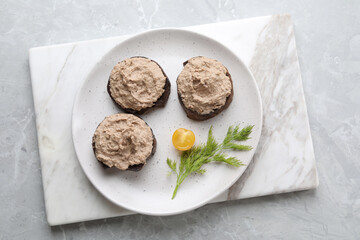 Slices of bread with delicious pate, tomato and dill on light grey marble table, top view