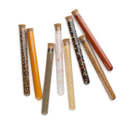 Glass tubes with different spices on white background, top view