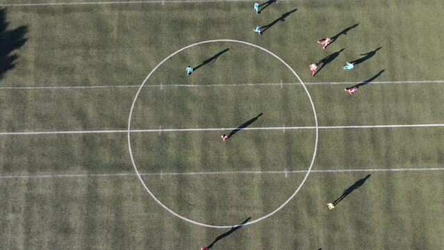 Aerial view of the football (soccer) field where players in red and blue jerseys play the match