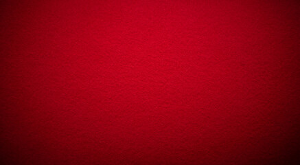 Photo of a fabric texture of crimson red color . The background is dark red with a black vignette. The texture of the felt fabric for the inscription.