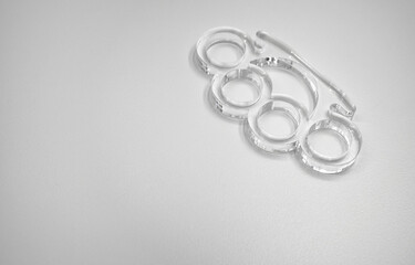 Glass brass knuckles on white isolate. Brass knuckles for the hand made of transparent polycarbonate.