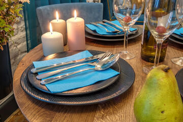burning candles on a table with flowers with glasses or fruits, intimate romantic atmosphere