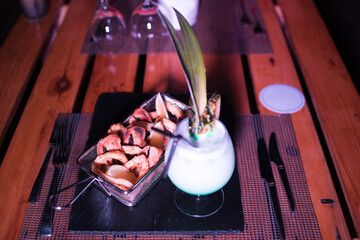 Small portion of onion rings with a cold cocktail drink beside it
