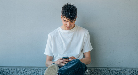 teenager sitting on the street with mobile phone