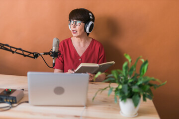 Middle-aged woman radio host making podcast recording for online show - broadcast and dj concept