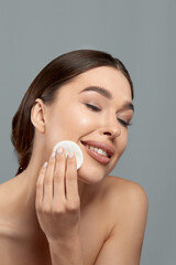 Woman Cleaning Face With White Pad. Beautiful Girl Removing Makeup White Cosmetic Cotton Pad. Happy Smiling Female Taking Off Makeup From Facial Skin With Cosmetic Pad. Face Skin Care.